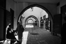 Image du Maroc Professionnelle de  Dans une rue des Habous, la succession des balèvres, moulure, arches, portiques et autres éléments décoratifs, projetent les visiteurs dans l’ardeur avec un élan de force et de fierté d’une époque révolue. Conçu par les architectes Auguste Cadet et Edmond Brion d’après l’ébauche d’un premier plan-masse dû à Albert Laprade, le quartier fait partie des endroits les plus pittoresques de Casablanca, il fut La construction n’avait commencé qu’après la première guerre mondiale. Situé près du Palais Royale, ce joyau architectural fait partie du patrimoine architectural de la ville, Samedi 8 Novembre 2008. Au centre le minaret de La mosquée Ben Youssef. (Photo / Abdeljalil Bounhar)
 